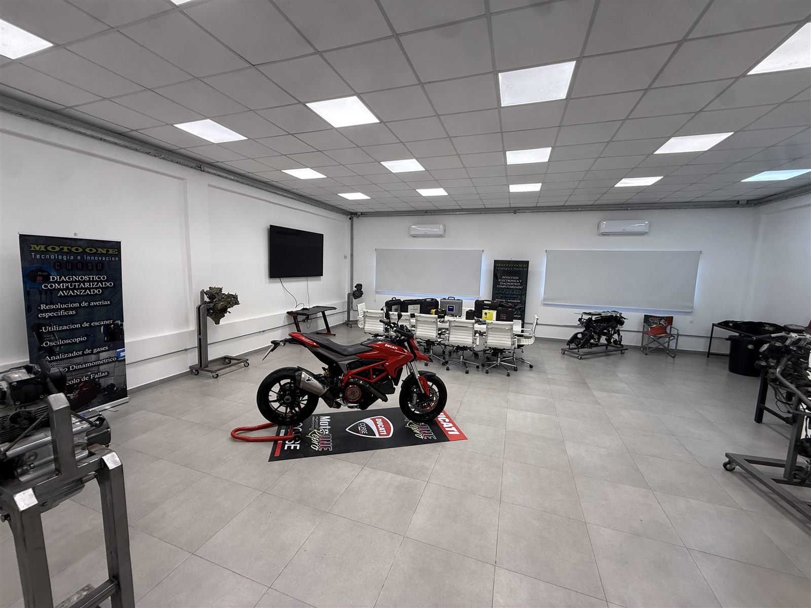 Aula taller de Repro One Academy con motocicletas y espacio de formación